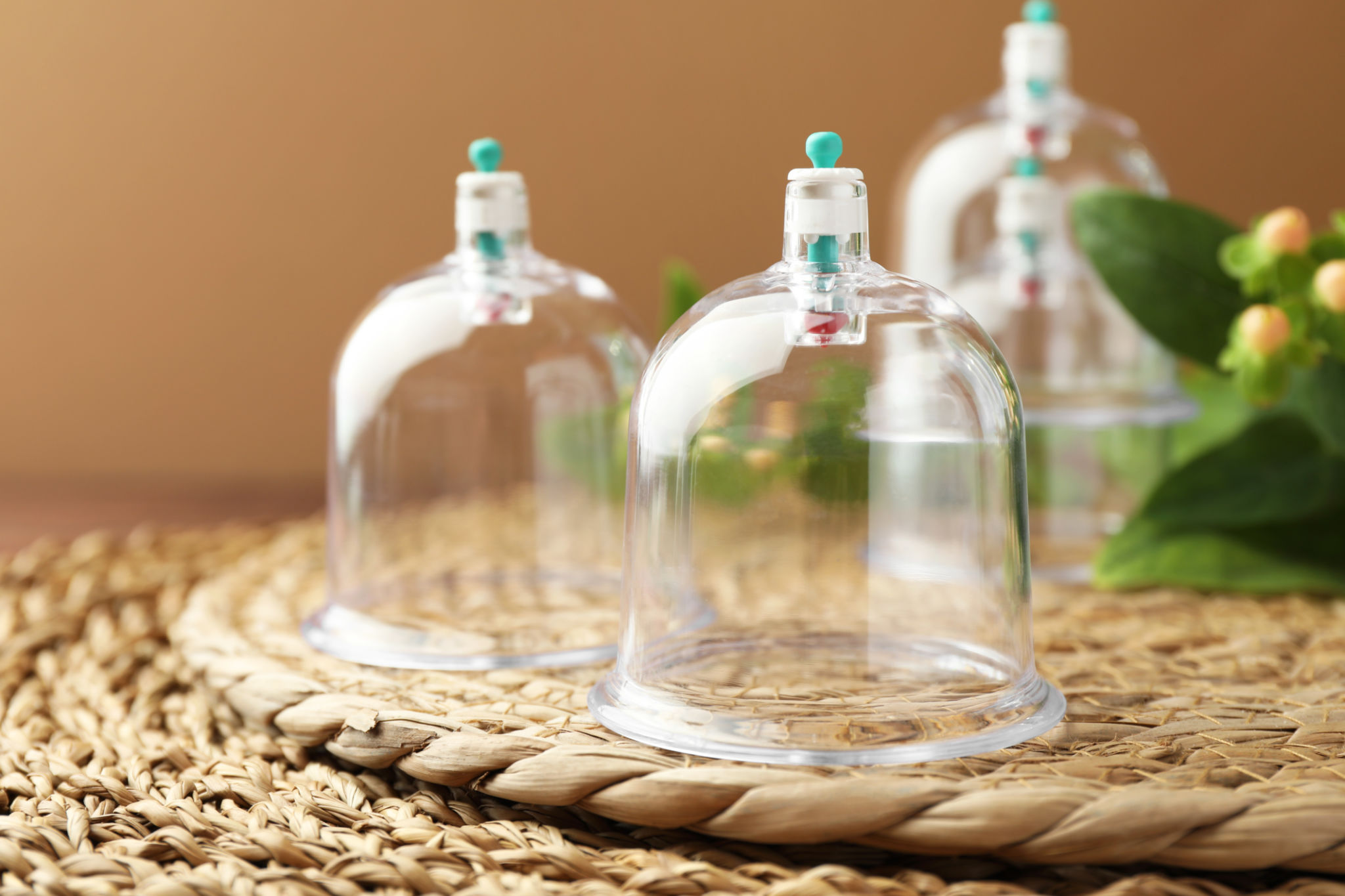 Cupping therapy. Plastic cup on wicker mat, closeup Cupping therapy. Plastic cup on wicker mat, closeup