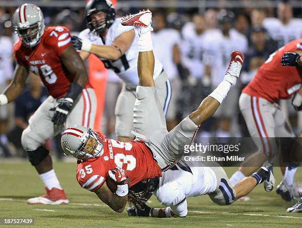 Tim Cornett of the UNLV Rebels is tackled by Brian Suite of the Utah State Aggies during their game at Sam Boyd Stadium on November 9, 2013 in Las...