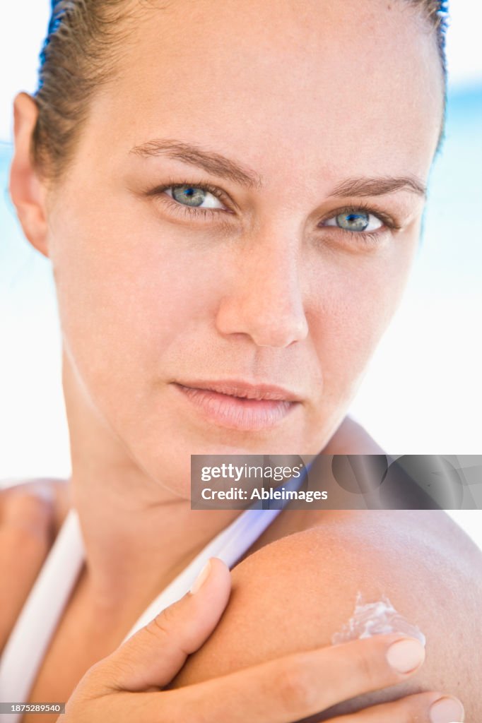 Young Woman Applying Body Lotion on Shoulder