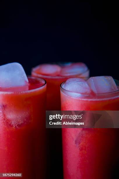 three glasses of raspberry juice with ice - bloody mary stock pictures, royalty-free photos & images