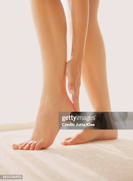 woman applying body lotion on heel, low section - creme corporal imagens e fotografias de stock