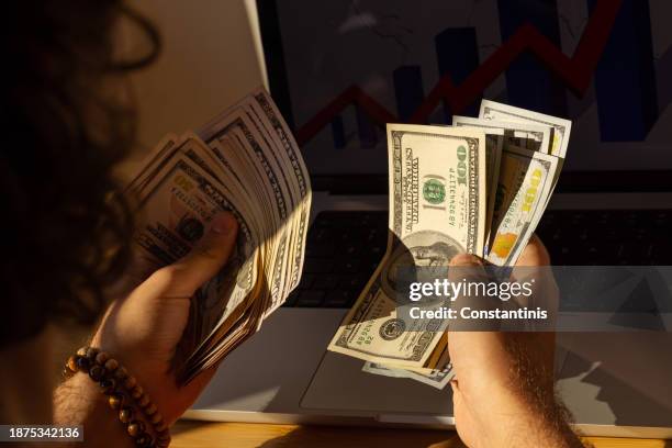 close-up of an unrecognizable male entrepreneur counting dollars - saving up for a rainy day stock pictures, royalty-free photos & images