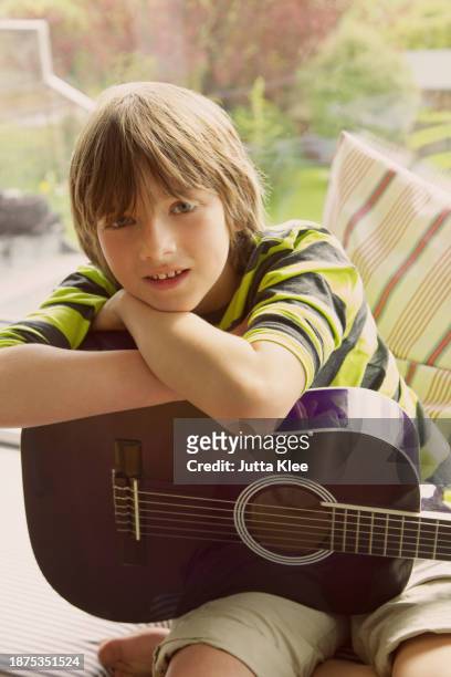 boy holding guitar - acoustic guitar close up stock pictures, royalty-free photos & images
