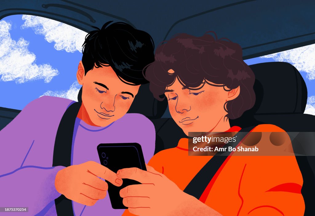 Tween brothers using smart phone together in back seat of car
