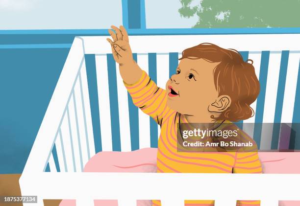 cute baby girl with arm raised reaching from crib in nursery - baby girls stock illustrations