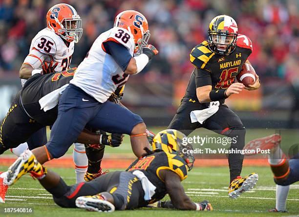 Maryland quarterback C.J. Brown , left, takes off on a run as Syracuse linebacker Cameron Lynch , center, closes in as the Maryland Terrapins play...