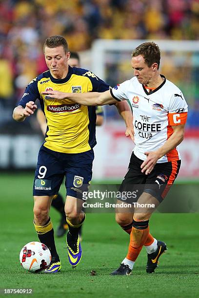 Mitchell Duke of the Mariners competes with Matthew Smith of the Roar during the round five A-League match between the Central Coast Mariners and...