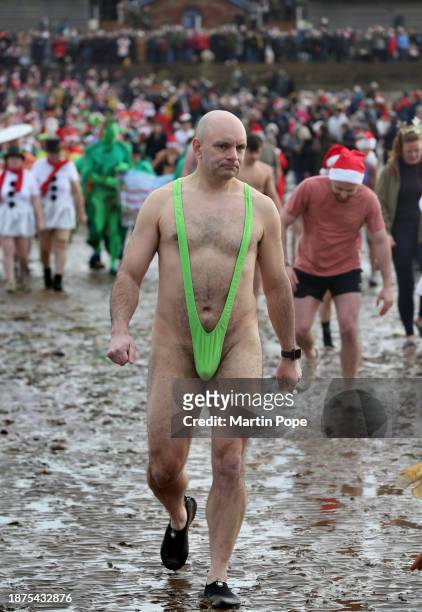 Ben Jones in his mankini joins the charity swimmers on the beach on December 25, 2023 in Hunstanton, England. The traditional festive swim has a...