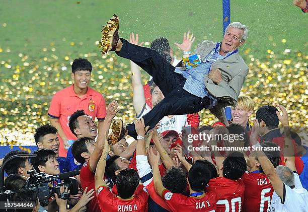 Marcello Lippi, head coach of Guangzhou Evergrande, is thrown in the air by his players as they celebrate after the AFC Champions League Final 2nd...