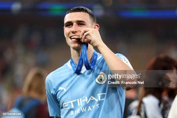 Phil Foden of Manchester City bites their winner's medal after the team's victory in the FIFA Club World Cup Saudi Arabia 2023 Final between...