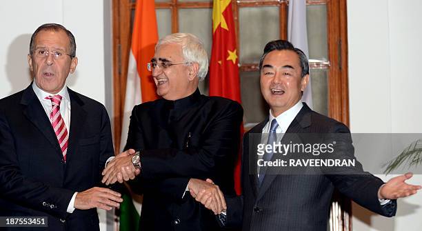 Indian Minister for External Affairs Salman Khurshid with Russian Foreign Minister Sergei Lavrov and Chinese Foreign Minister Wang Yi shake hands...