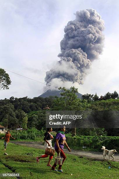 Residents flee the area following the eruption of Sinabung volcano at Kuta Gugung village, some 2 kilometers away from the volcano, in Karo on...