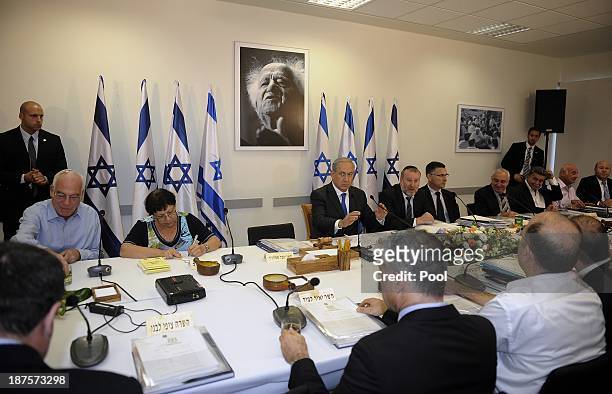 Israeli Prime Minister Benjamin Netanyahu sits under a portrait of the first Israeli prime minister David Ben Gurion as he overseas a cabinet meeting...