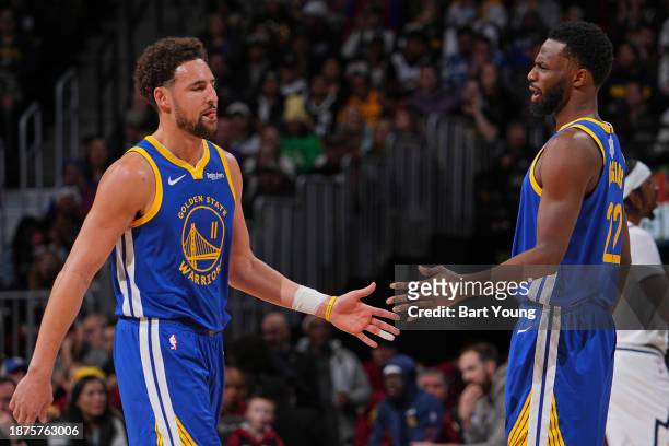 Klay Thompson and Andrew Wiggins of the Golden State Warriors high five during the game against the Denver Nuggets on December 25, 2023 at the Ball...