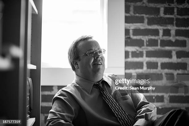 male profesional sitting and smiling - candid black and white corporate stock pictures, royalty-free photos & images