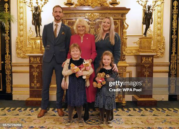 Queen Camilla with seven-year-old Olivia Taylor from Sidcup along with her sister Imogen, four, , father Matt , and mother Lisa at Windsor Castle,...