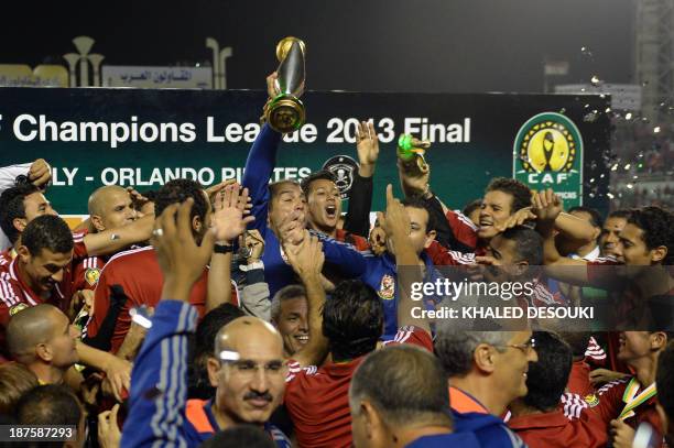 Egyptian al-Ahly coach Mohamed Youssef holds up the African Champions League trophy in Cairo, on November 10 after defeating Orlando Pirates of South...