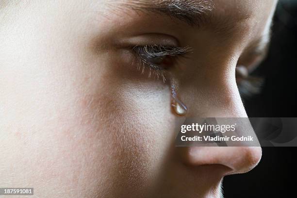 close-up of a girl shedding a tear - teardrop stockfoto's en -beelden