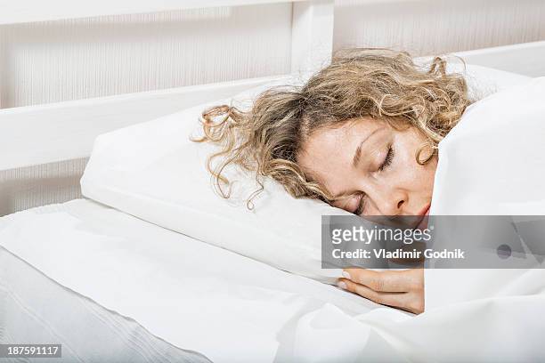 woman sleeping n bed - man sleeping pillow stock-fotos und bilder