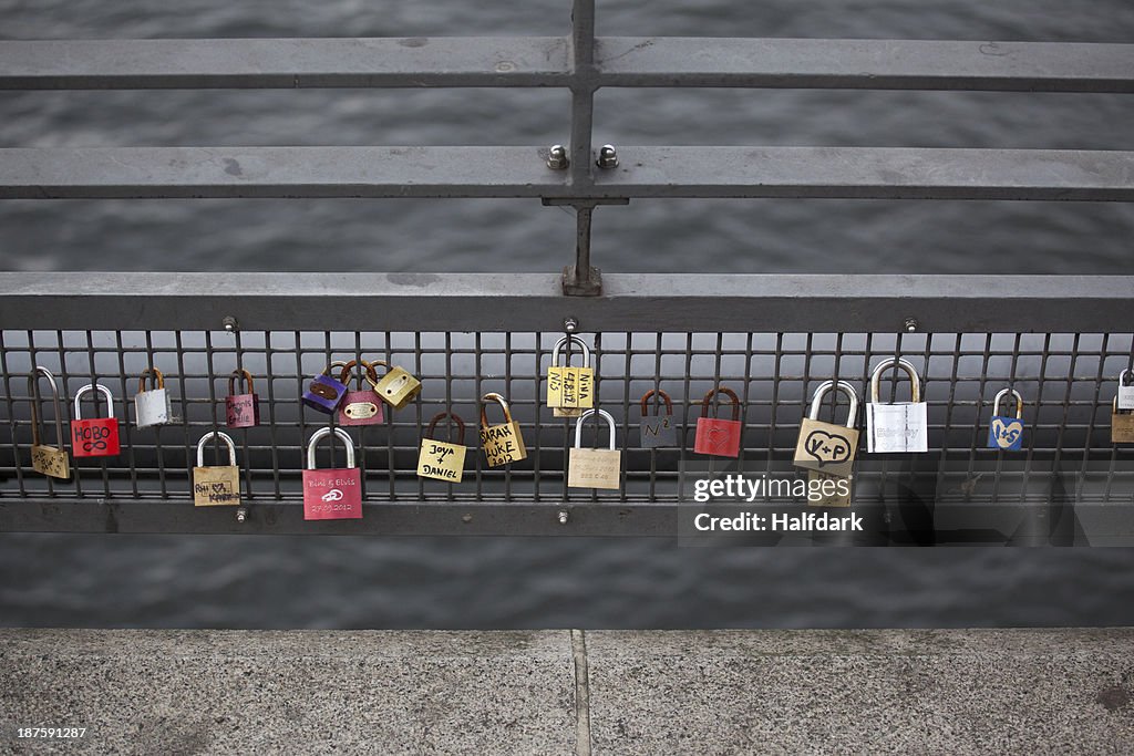 Love padlocks hanging in a row on a bridge railing in Berlin, Germany