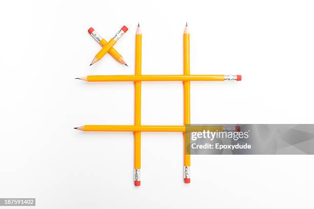 pencils arranged into a tic-tac-toe game with a single x played - tic tac toe stock-fotos und bilder