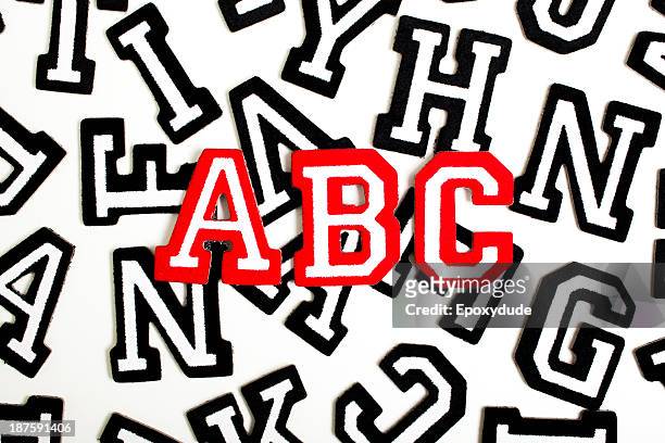 red outlined varsity font stickers spelling abc on top of black outlined letters - varsity stock pictures, royalty-free photos & images