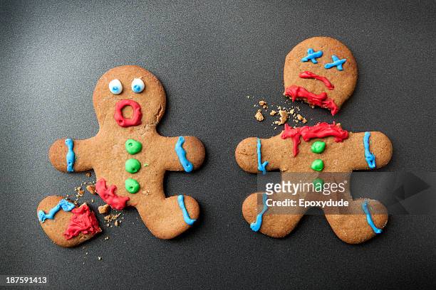 a shocked gingerbread man with broken leg next to a decapitated gingerbread man - bloody death stock pictures, royalty-free photos & images