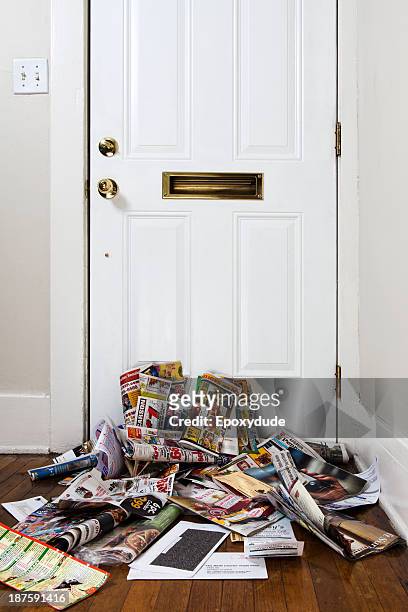 a heap of mail and newspapers under a mail slot in a home entrance hall - large group of objects stock pictures, royalty-free photos & images
