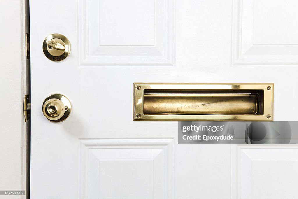 A front door with mail slot, doorknob and deadbolt lock