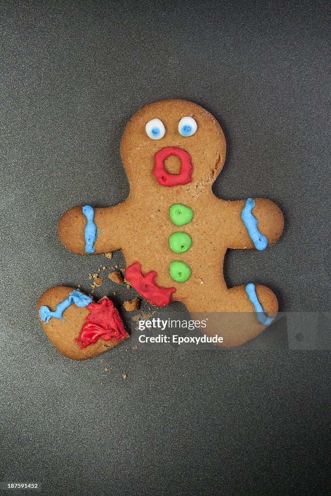 A gingerbread man looking shocked with a broken leg