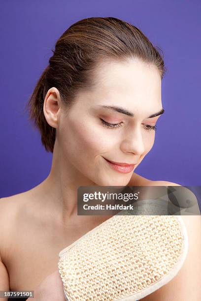 a smiling young woman using a loofah sponge - loofah stock pictures, royalty-free photos & images