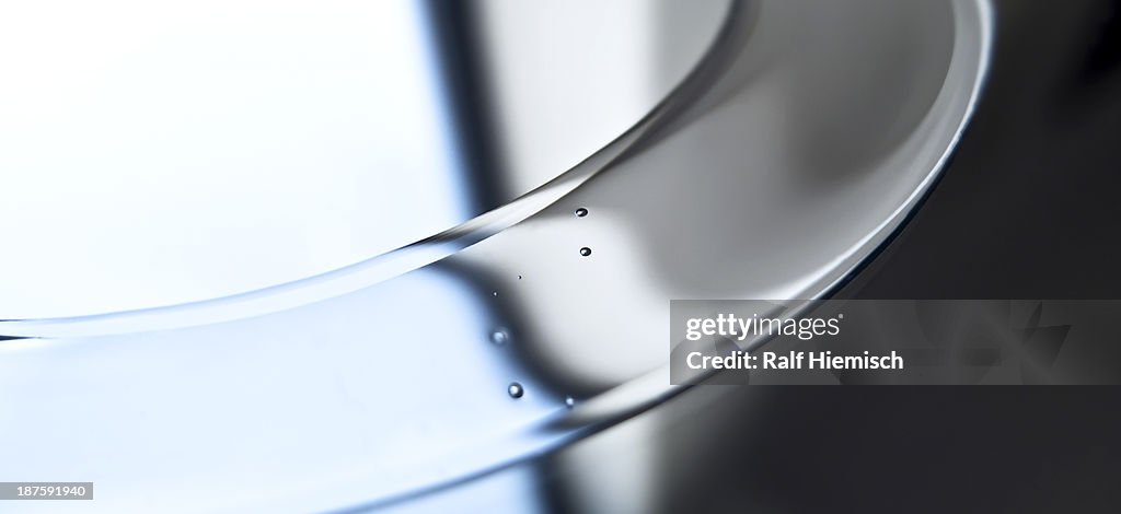 An abstract shiny silver surface with tiny drops on it