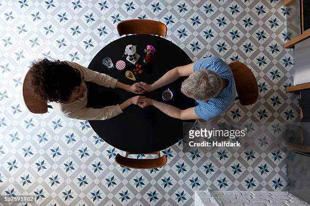 a mixed age couple holding hands at the breakfast table, directly above - dating stock-fotos und bilder