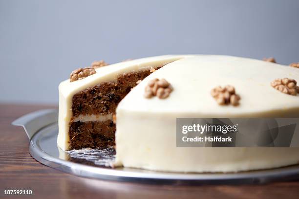 a carrot cake with a slice missing for sale in a cafe - cake sale stock-fotos und bilder