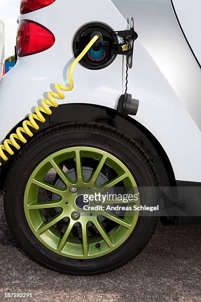 detail of a charger connected to an electric car recharging - innovation hub stock pictures, royalty-free photos & images