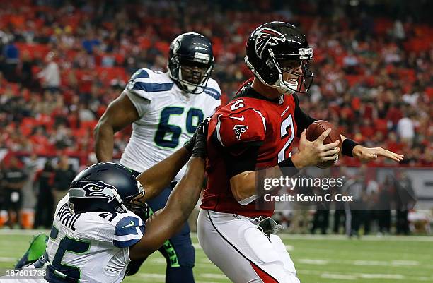 Matt Ryan of the Atlanta Falcons draws a horse-collar penalty from Cliff Avril of the Seattle Seahawks at Georgia Dome on November 10, 2013 in...