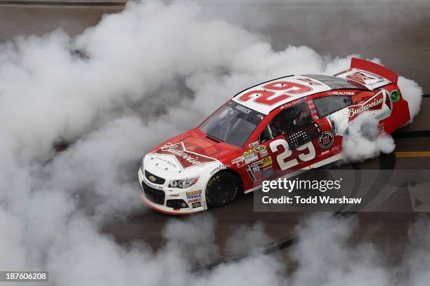 Kevin Harvick, driver of the Budweiser Chevrolet, celebrates with a burnout after winning the NASCAR Sprint Cup Series AdvoCare 500 at Phoenix...