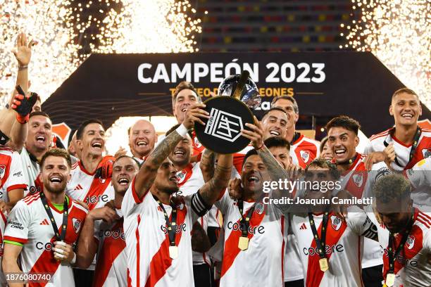 Jonatan Maidana and Enzo Pérez of River Plate lift the trophy with teammates after winning the Trofeo de Campeones match between Rosario Central and...