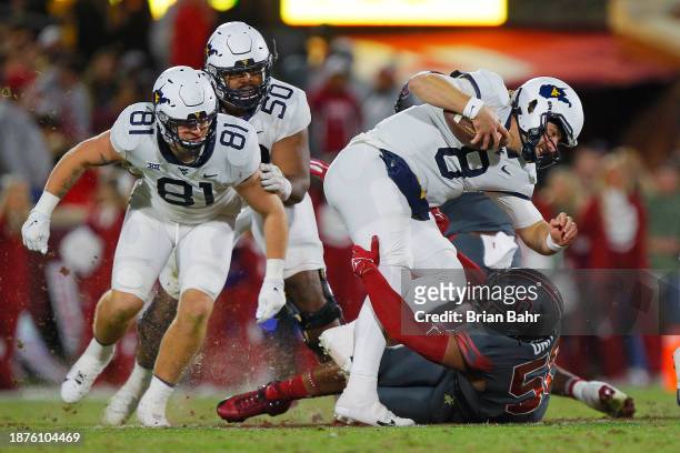 Defensive lineman Gracen Halton of the Oklahoma Sooners sacks quarterback Nicco Marchiol of the West Virginia Mountaineers for a three-yard loss in...