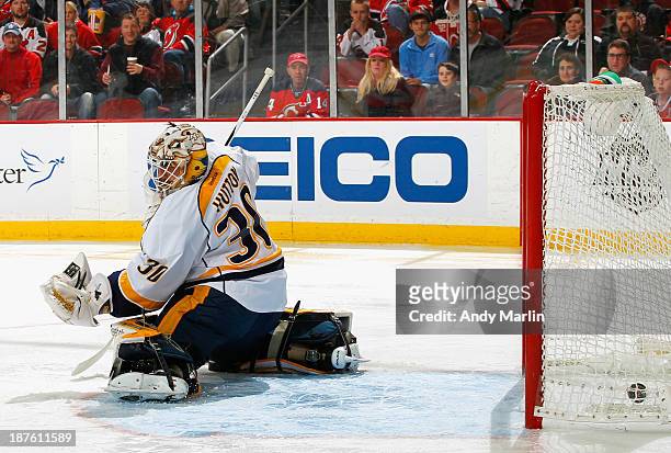 Jaromir Jagr of the New Jersey Devils puts the puck past Carter Hutton of the Nashville Predators for a first-period goal and his 1700th career NHL...