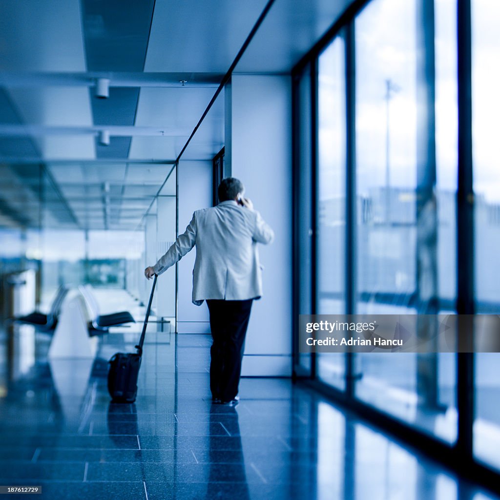 Businessman looking through a window in an airport