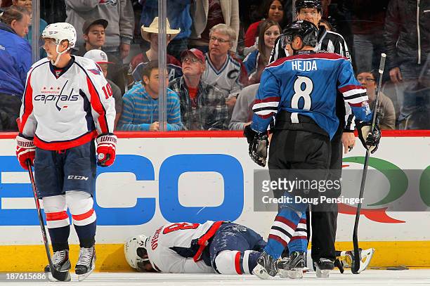 Alex Ovechkin of the Washington Capitals lies on the ice after taking a hit from Jan Hejda of the Colorado Avalanche in the second period at Pepsi...