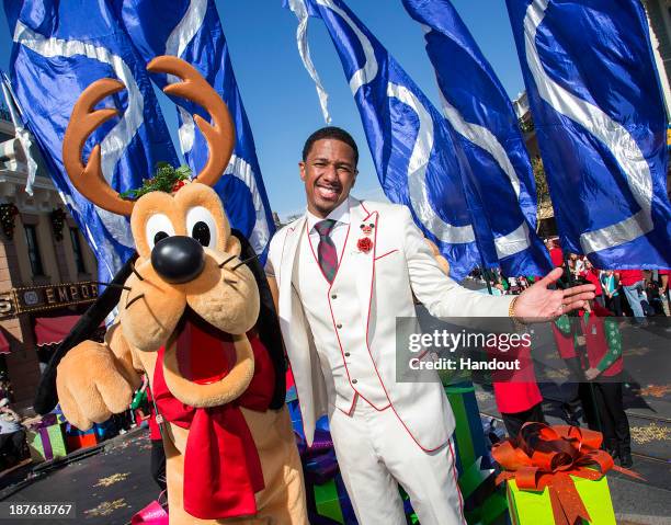 In this handout photo provided by Disney Parks, Host Nick Cannon meets Pluto during a break from taping the 'Disney Parks Christmas Day Parade'...