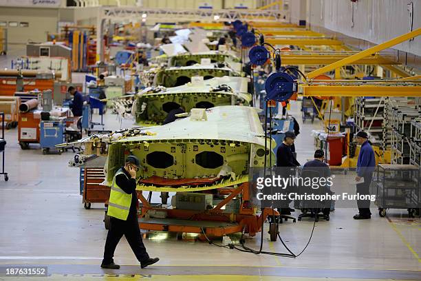 Technicians work on the wing of an Airbus A320 during construction at the Airbus SAS factory on November 7, 2013 in Broughton, United Kingdom. The...