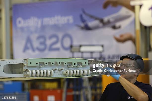 Technician works on the wing of an Airbus A320 during construction at the Airbus SAS factory on November 7, 2013 in Broughton, United Kingdom. The...