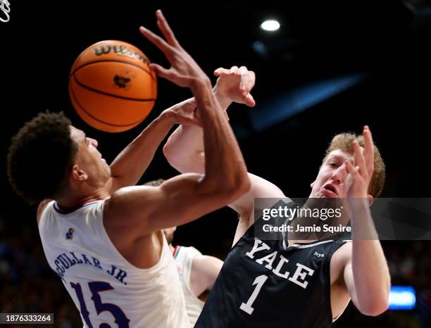 Kevin McCullar Jr. #15 of the Kansas Jayhawks and Danny Wolf of the Yale Bulldogs compete for a loose ball during the game at Allen Fieldhouse on...