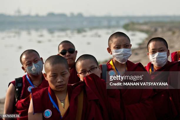 Tibetan buddhist monks attend a prayer meeting on the banks of river Yamuna in New Delhi on November 11, 2013 as part spiritual leader, the 17th...