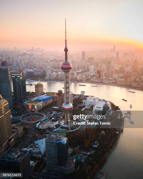 oriental pearl tv tower rising over shanghai skyline aglow: aerial sunset splendor of the mega-city in china - oriental pearl tower stock pictures, royalty-free photos & images