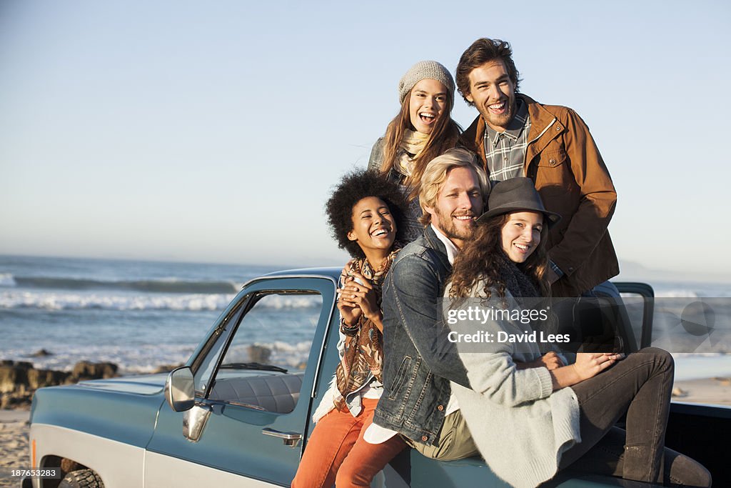 Friends at beach sitting in truck