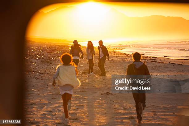 friends walking on beach together - carefree beach stock pictures, royalty-free photos & images